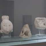 Osserviamo frammenti scultorei, grifi, leoni alati...